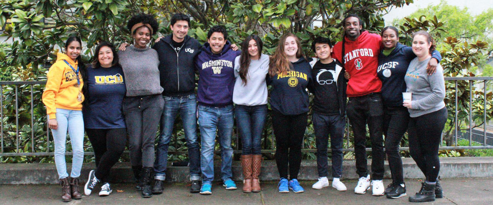 Group of students wearing different university logo shirts