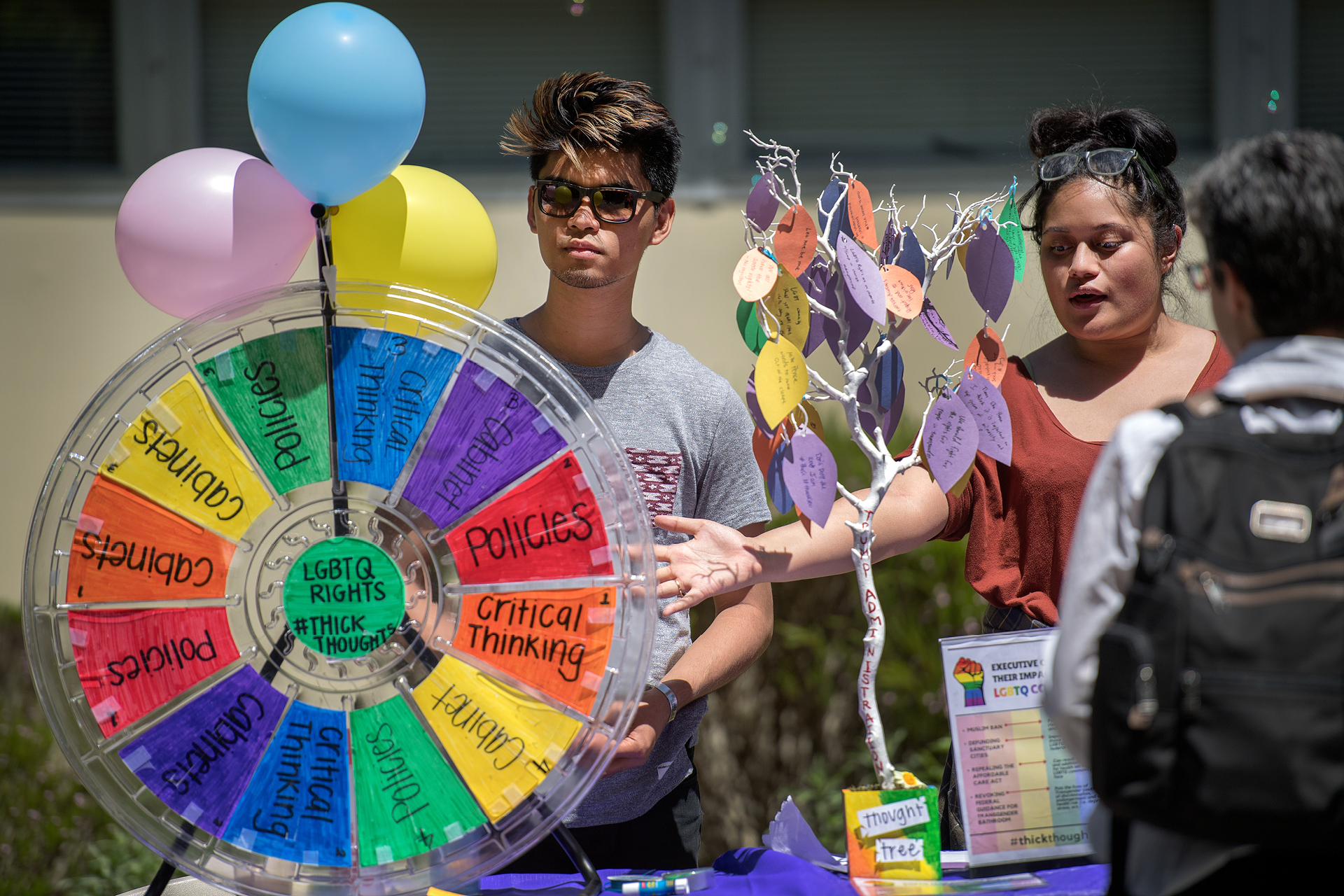 SF State student spin wheel of choice tabling game in quad
