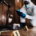 Photo of forensic specialist collecting samples at crime site