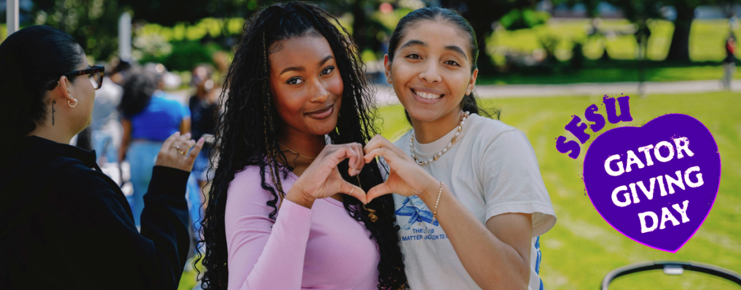 2 students making a heart next to a logo for Gator Giving Day